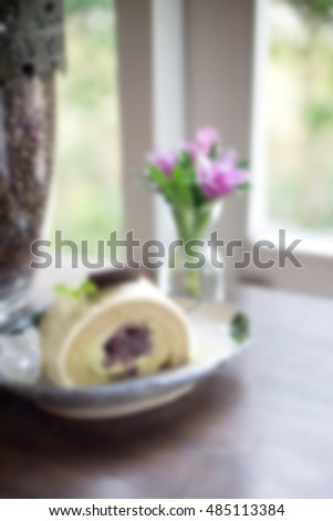 blur view of cake in dish near window in coffee shop