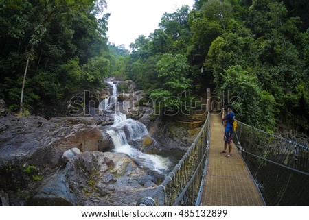 Tourist taking a picture the beautiful nature landscape of Lasir waterfall, Kenyir Lake, Terengganu, Malaysia. Lasir Waterfall also known as Air Terjun Lasir.