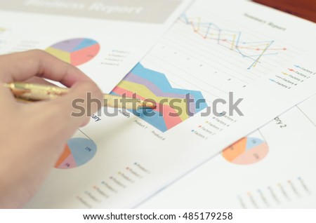Men handle pen pointing document chart on table
