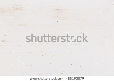 Small golden stars confetti on white wooden background. Royalty-Free Stock Photo #485193079