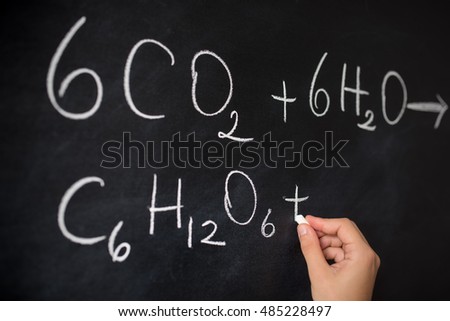 University student writing on blackboard