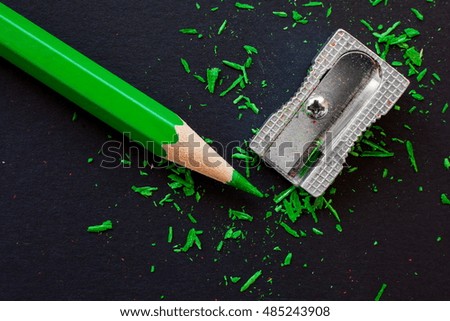 green wooden pencil and sharpeners on black