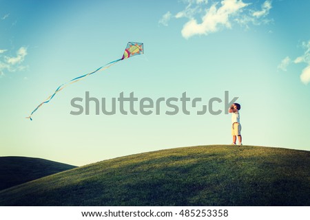 Little boy on summer vacation having fun and happy time flying kite on the sea beach Royalty-Free Stock Photo #485253358