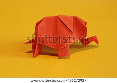 Origami elephant out of paper isolated on a colored background