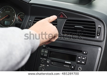 finger hitting car emergency light botton, man pressing red triangle car hazard warning button, Warning of the danger and stop