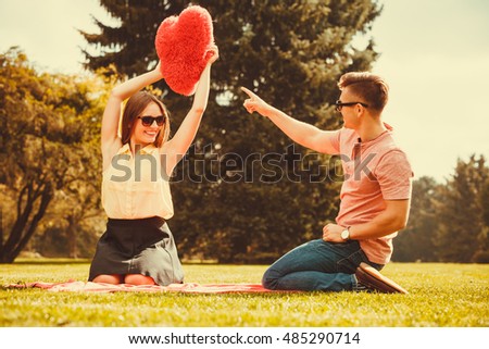 Love romance dating relationship leisure concept. Couple playing games in park. Girl and her man passing heart spending time on picnic. 