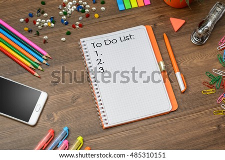 To do list. Business (school) accessories (notebook, diary, mobile phone, cactus, pens, pencils) on a wooden table. Top view.