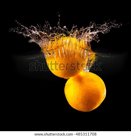 Group of fresh fruits falling in water with splash on black background.