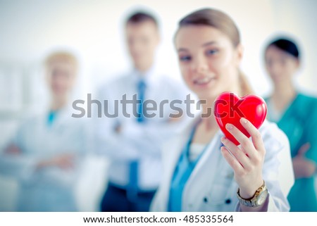 Female doctor with stethoscope holding heart