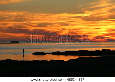 Silhouette of fishermen with yellow and orange sunset.