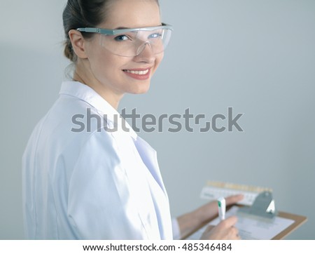 Attractive female dentist with tools , standing on gay background