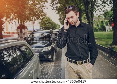 A guy in a nice town, walking, listening to music and taking pictures themselves on the phone