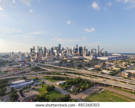 Aerial view downtown and interstate 45 and 69 highway intersection, massive intersection, stack interchange and elevated road junction overpass at sunset from the southeast side of Houston, Texas, USA