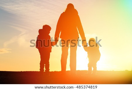 mother and two kids travel at sunset