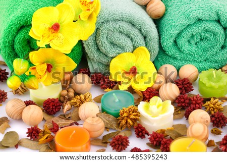 Spa set with towels, candles, wooden balls and flowers closeup picture.