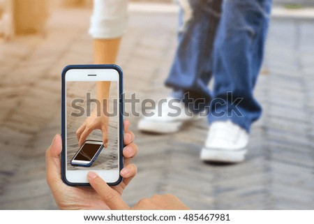 Woman Taking photo with mobile phone, Cellphone on blurred background  people Picking Smart Phone on the walkway.