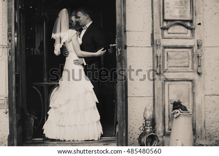 Black and white picture of a wedding couple standing in the old entrance