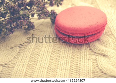 Fresh colorful macaroons on woolen knitted background. Winter and Christmas days lifestyle background. Holidays at home. Vintage styled background.