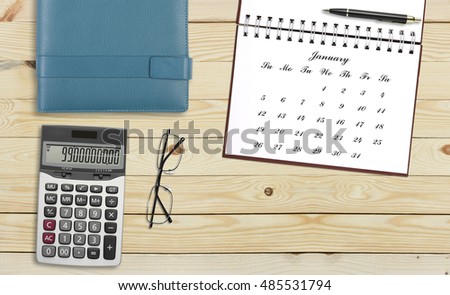 top view blank january calendar or new year in dairy with calculator, pen, glasses and notebook on the desk or table for your plan