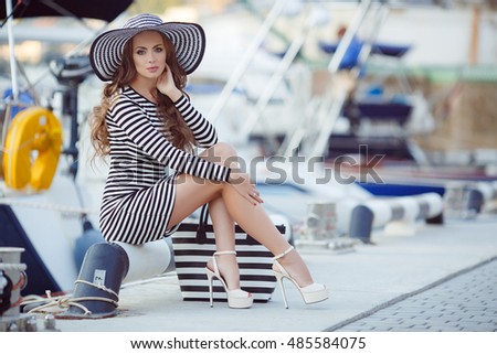 portrait of beautiful young smiling woman near the boats and yachts. Outdoors, lifestyle. Beautiful woman near the boats and yachts. Fashion. sea or ocean background.