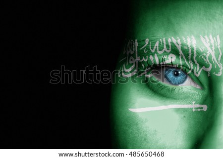 A young female with the flag of Saudi Arabia painted on her face on her way to a sporting event to show her support.