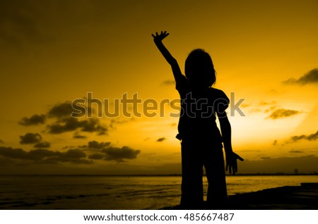 Kid raise hand for success near beach