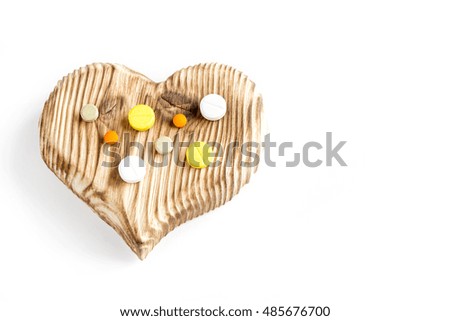 wooden texture heart with pills on the background of the wooden planks. the idea of ecology natural treatment
