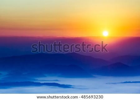Fantastic sunrise over the mountains shrouded in the mist. Carpathian, Ukraine, Europe. Beauty world