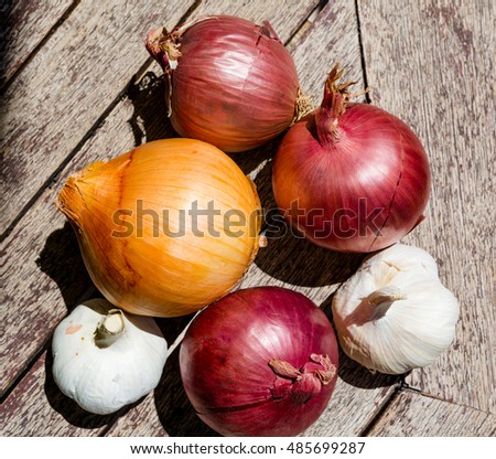 Cooking ingredients: onions and garlic on a wooden table