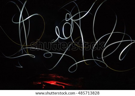 Abstract weird light painted pattern on black background. Light painting artwork at night by campfire