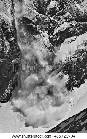 Black-and-white picture of an avalanche descending from slopes of mountains in the Himalayas.