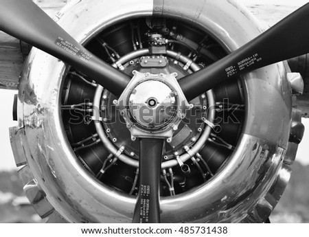 Black and white photograph of a three-propellered airplane engine.