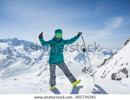 Girl snowboarder on the background of high snow-capped Alps in sun day, Austria 