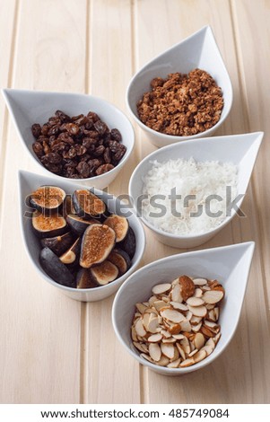 Breakfast buffet bar  with dry fruit, nuts, fruit, coconuts. Bright sun lit room. 