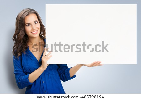 Happy smiling beautiful young woman showing blank signboard or copyspace