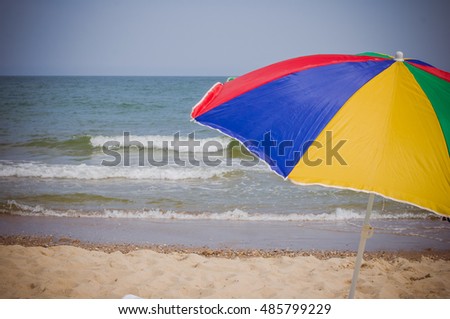 Umbrella on sandy beach with a sea view