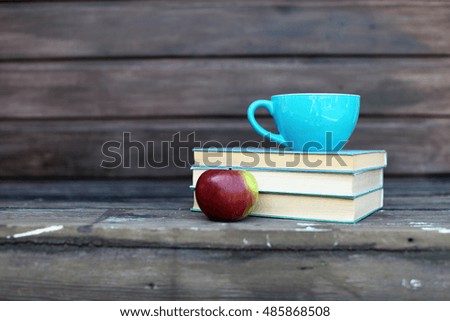 stack of books and red apple on a white background. horizontal photo.