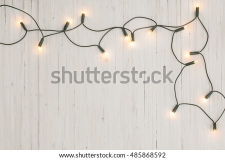 christmas lights on white wooden background