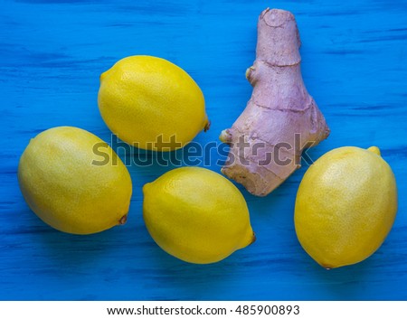 Ripe lemons and root of ginger on the blue background