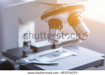 medical laboratory, scientist hands using microscope for chemistry ,biology test samples,examining liquid,Doctor equipment,Scientific and healthcare research background.vintage color