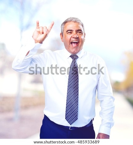 mature man doing a rock gesture