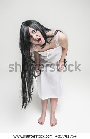Mystical witch screaming woman looking at you on gray background