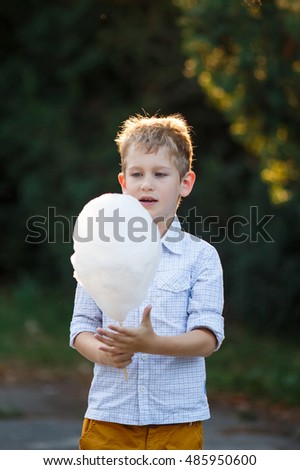 Funny boy with cotton candy in the park
