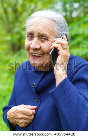 Picture of a happy old woman receiving good news by phone