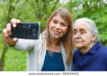 Picture of a beautiful young woman taking selfie with her grandmother