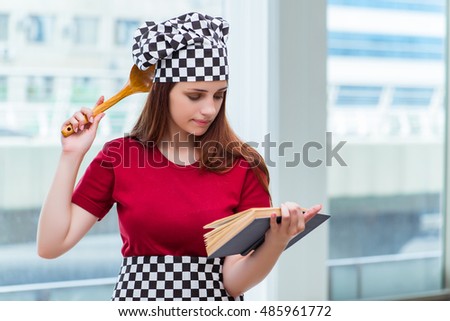 Young housewife referring to recipe book
