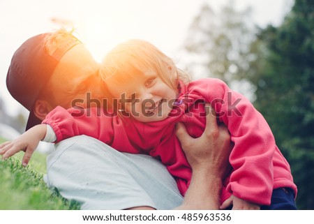 Cheerful father and cute daughter spending time in the park, happy family, intentional sun glare