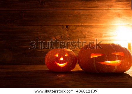 Two pumpkin with candle over wooden background. Halloween pumpkin background. Jack-O-lantern.
