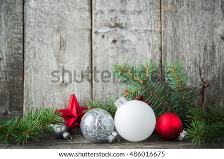 Red, silver and white xmas ornaments on rustic wood background. Merry christmas card. Winter holiday theme. Happy New Year. Space for text.