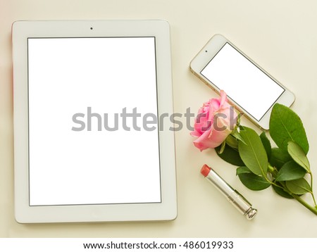 Styled flat desktop scene with white tablet, mobile and flowers